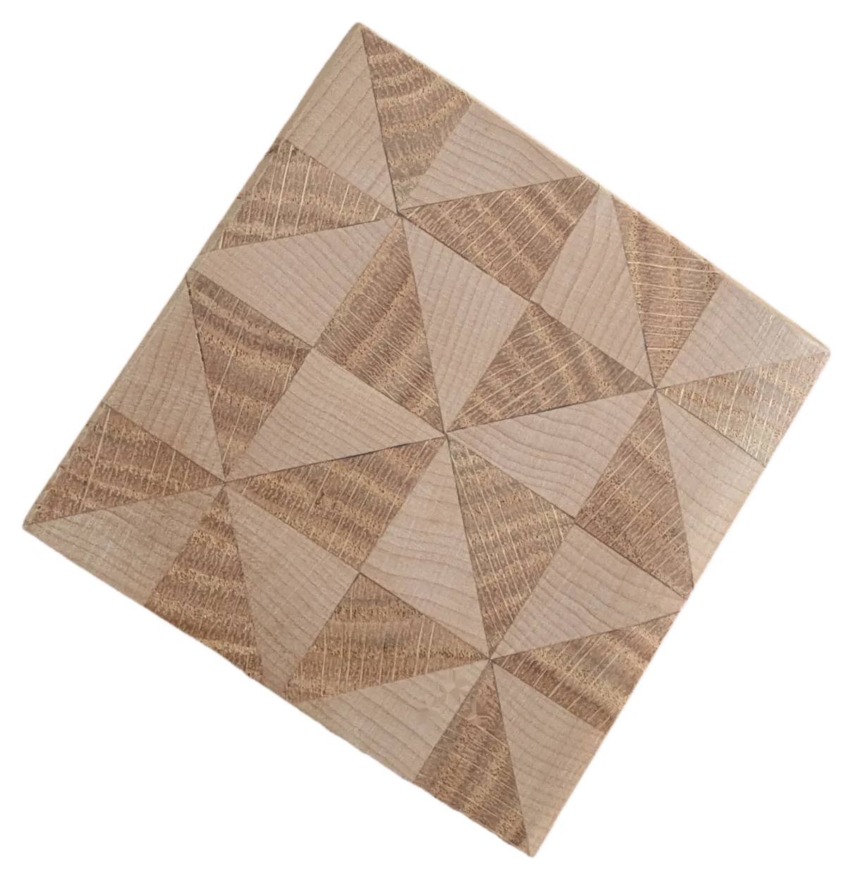 A single end-grain coaster in white oak, its blocks arranged in a pinwheel